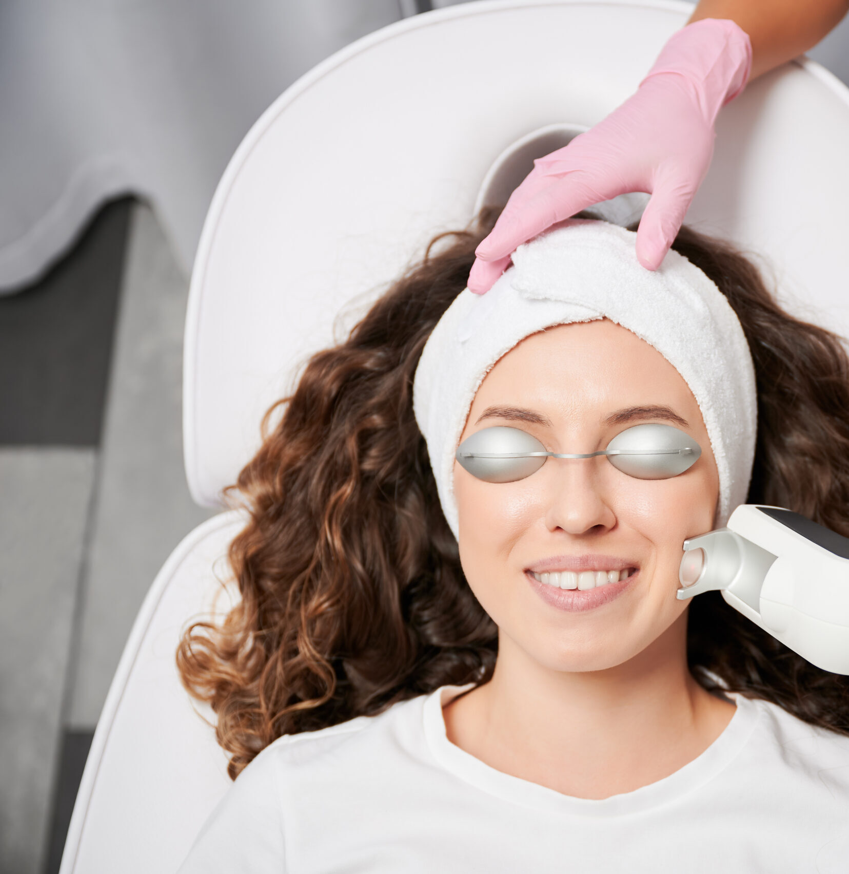 Close-up view laser correction process of vascular asterisks on face in clinic of hardware cosmetology. Doctor working with modern yellow laser for treating vascular defects of face and body.